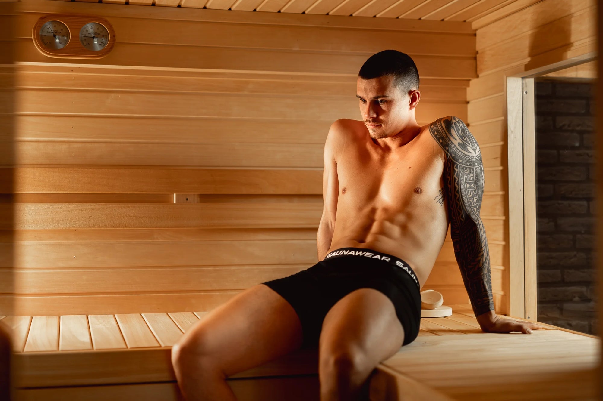 Man sitting in a wooden sauna wearing Saunawear